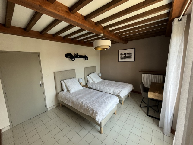 Cette image présente la chambre 2 de la chambre d'hôte Sean Connery du Temps des Légendes. Elle est composée de 2 lit de 90 x 200 cm, qui peuvent être sur demande réunit en 1 lit de 180 x 200 cm. La chambre est équipée d'un bureau, de 2 fauteuils et d'un grand dressing.