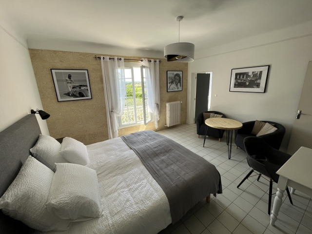 Chambre Steve McQueen Cette image présente la chambre d'hôte Steve McQueen du Temps des Légendes. Elle est composée d'1 lit de 180 x 200 cm. La chambre est équipée d'une table, 2 fauteuils, d'un bureau avec fauteuil et d'un grand dressing.