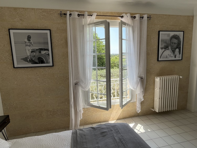 Esprit King of Cool et luminosité Cette image présente la chambre d'hôte Steve McQueen du Temps des Légendes. Elle est composée d'1 lit de 180 x 200 cm. La chambre est équipée d'une table, 2 fauteuils, d'un bureau avec fauteuil et d'un grand dressing.