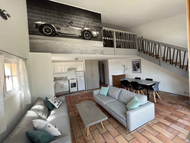 Séjour salon cuisine Gîte Shelby Cette image présente le séjour de 41m2 du gîte Shelby de Le Temps des Légendes, comportant une cuisine équipée, un salon télévision avec 2 canapés 3 places, ainsi qu'un espace repas pour 6 personnes.