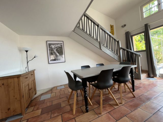 Espace repas style industriel pour 6 personnes Cette image présente l'espace repas style industriel pour 6 personnes, dans le vaste séjour lumineux de 41m2 du gîte Shelby de Le Temps des Légendes, comportant une agréable cuisine équipée et fonctionnelle, un confortable salon télévision avec ses 2 canapés cuirs 3 places.