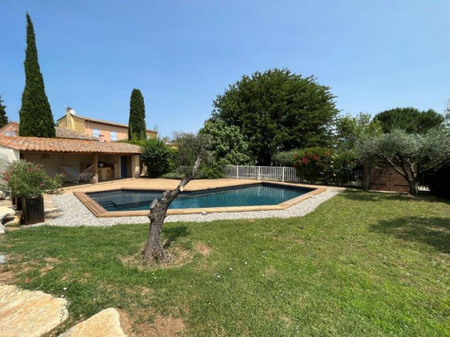 Vue sur l'espace piscine sécurisé Cette image présente la piscine du Temps des Légendes. Elle est sécurisée par une clôture et arborée par des oliviers et une haie végétale.
